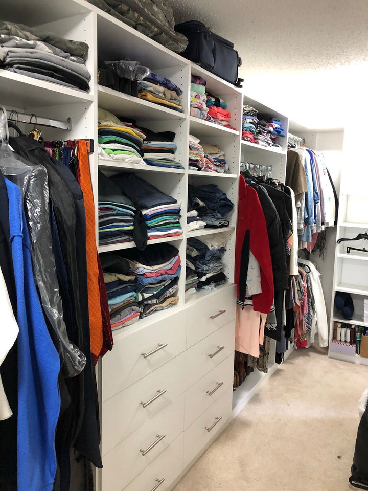 Walk-in closet in use, with folded clothes, drawers and hanging space