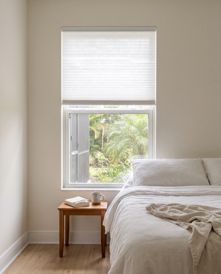 White cellular honeycomb shade on a bedroom window