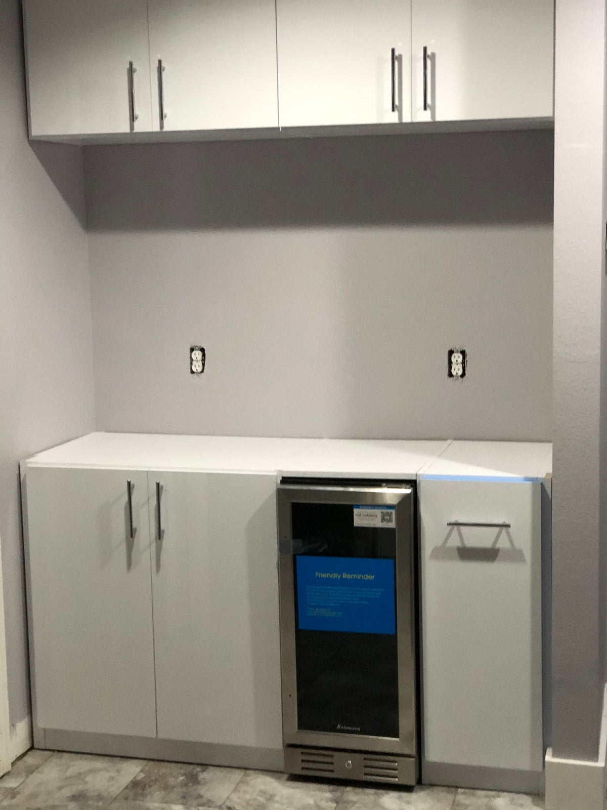 White upper and lower cabinets with a built-in beverage fridge