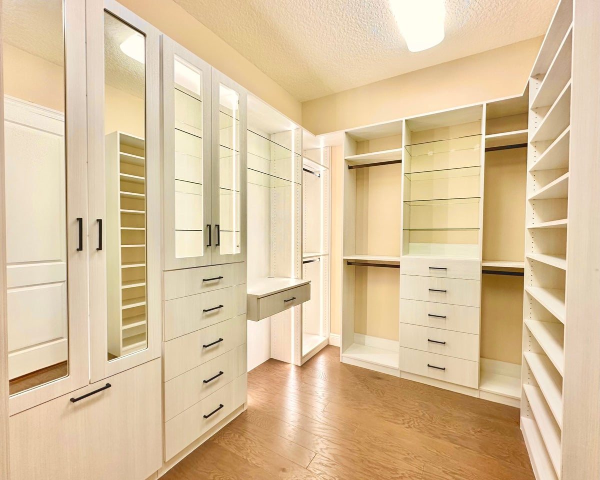 Walk-in closet with glass-front cabinets, a vanity drawer and shoe shelves