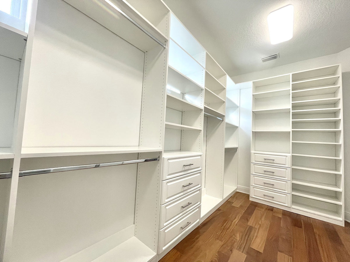 White walk-in closet with open shelving, drawers and double hanging over a wood floor