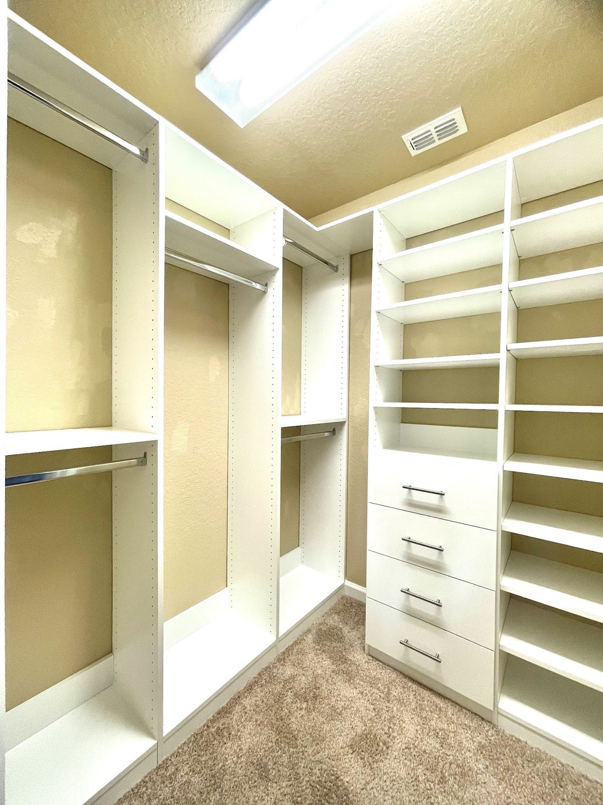 Walk-in closet with white shelving, drawers and double hanging